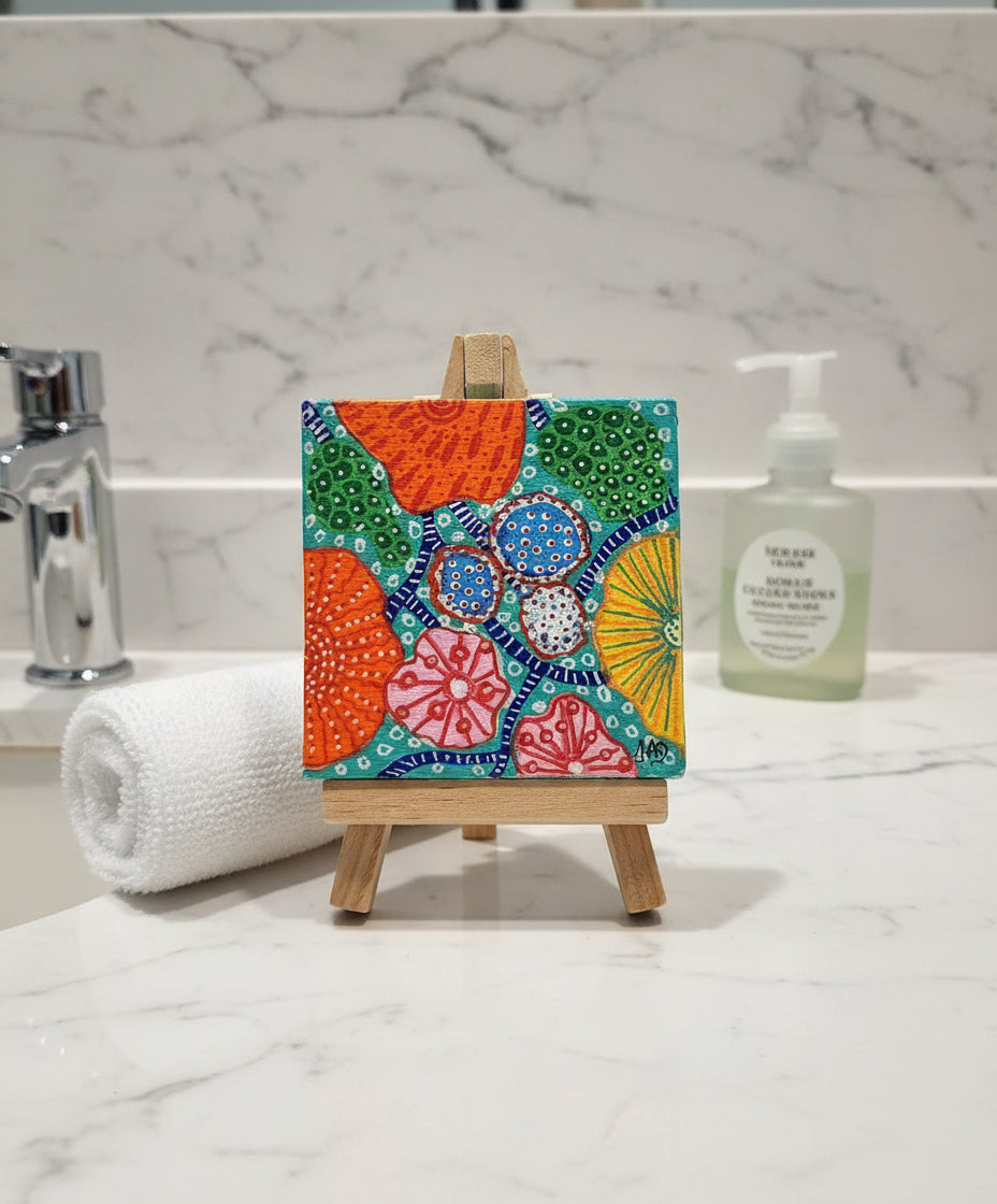 Colorful abstract painting on a small easel against a white background